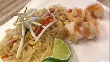 Pasta with shrimp and lime on a white plate.