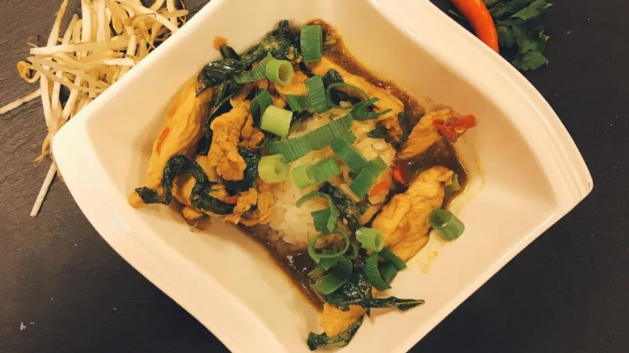 Chicken curry served with rice and vegetables in bowl.