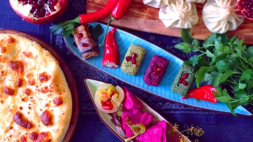 A variety of dishes are served on a table with fresh ingredients.