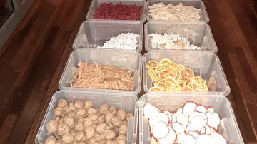 Various snack containers are placed on a wooden table.