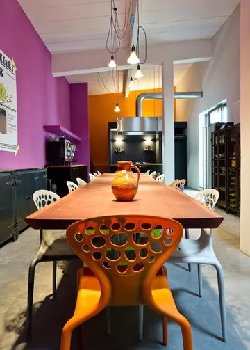 A large table with colorful chairs in a colorful room.