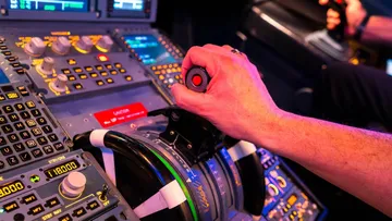 Ein Pilot steuert ein Flugzeug mit einem Joystick im Cockpit.