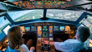 Cockpit mit zwei Piloten, die auf den Simulator einwirken.