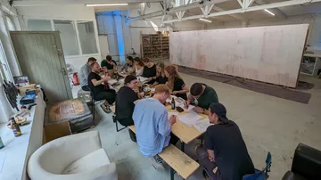 Group of people is working on an Art-Projekt in a studio.