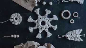 Crochet decorations and wooden beads lie on a dark table.
