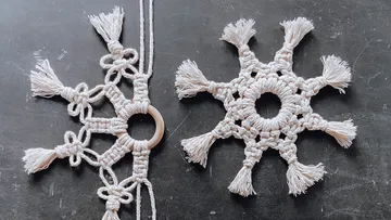 Two crocheted snowflakes made of cotton yarn on a black background.