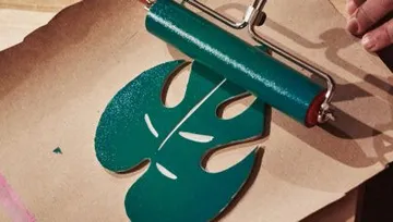 Green leaf design is printed with an ink roller.
