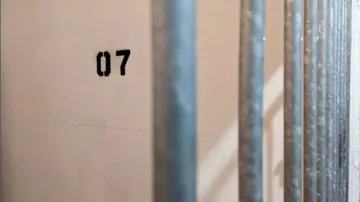 Stahlstäbe stehen vor Wand mit Nummer „07“ sichtbar.