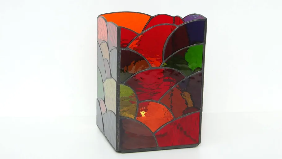 Vase made of colorful glass stands on a white background.