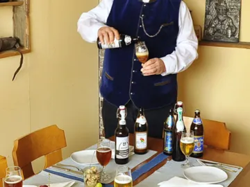 A waiter pours beer into a glass at the table.