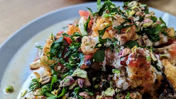 A plate of shrimp, herbs, and spices.