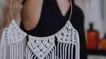 Handgemachter makramee Schmuck wird von einer Person gehalten.
