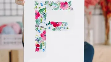 Buntes F auf weißem Papier, gehalten in einem Raum.