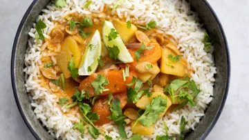 Bowl of rice, vegetables and coriander, served appetizingly.