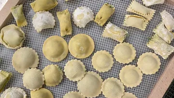 Homemade filled dumplings are laid out on a rack.