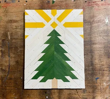 Colourful wooden tree with yellow background on wooden background.