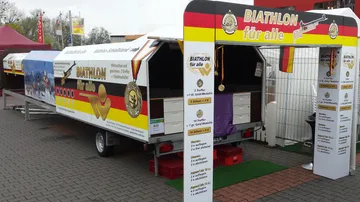 Biathlon stand with medals, offers games and participation.