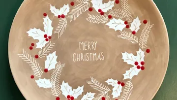 A plate with a Christmas wreath and 'MERRY CHRISTMAS' lettering.
