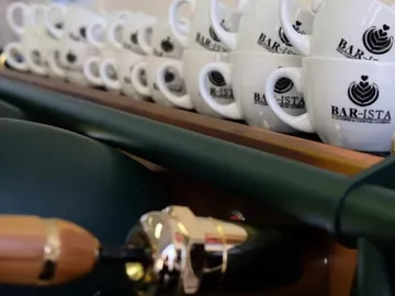 Cups are neatly placed on a shelf behind a beam.