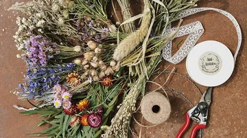 Colourful dried flowers and tools to tie on table