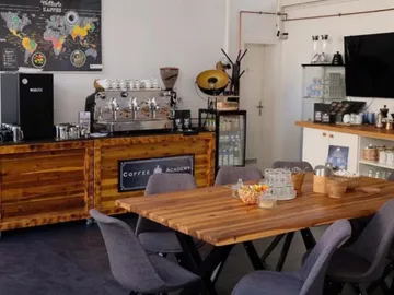 Wooden table with chairs surrounded by a coffee exhibition.