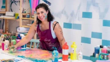Artist paints colorfully in a creative studio.