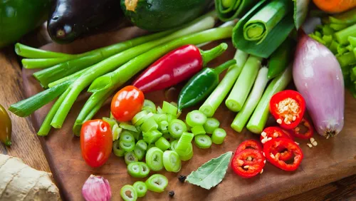 Gemüse liegt auf einem Holzbrett, frisch und bunt angeordnet.