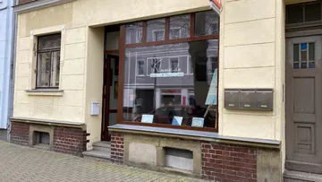 Ladenfront mit Fenstern, zeigt Bilder und Informationen.