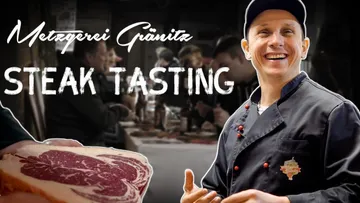 Steak wird verkostet, während Menschen an einem Tisch sitzen.