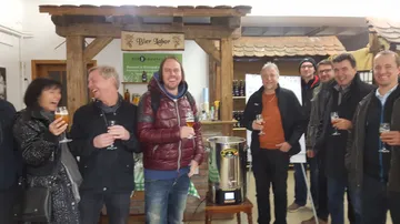 Group of people happily drinking beer in bar.