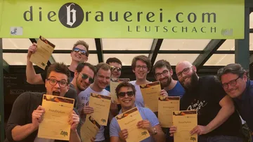 Certificates are held by a group of young men.