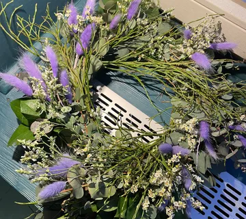 A circle of flowers lies on a blue surface.