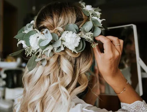 Haare mit Blumenkranz geschmückt, Person schaut in den Spiegel.