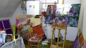 Kunstwerke und Malutensilien in einem kreativen Atelier.