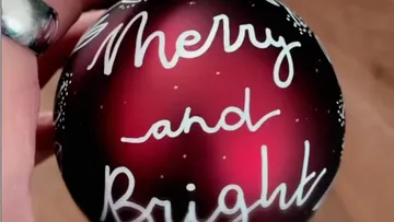 Red Christmas ball with the text “Merry and Bright.”