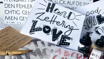 Papier mit handgeschriebenen Wörtern und Zeichen, künstlerische Umgebung.