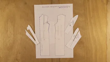 Patterns on paper with cut-outs for a dress.