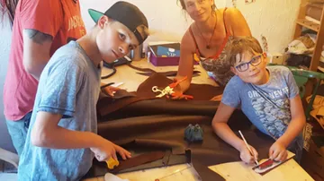Familie schneidet Leder in einem kreativen Atelier zusammen.