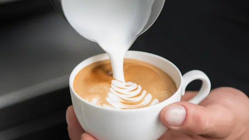 Coffee mug is covered with milk, creating a pattern.