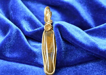 Gold pendant on blue velvet fabric.