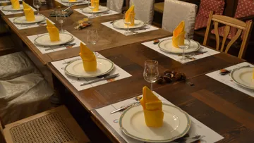 Ein festlich gedeckter Tisch mit gelben Servietten und Gläsern.