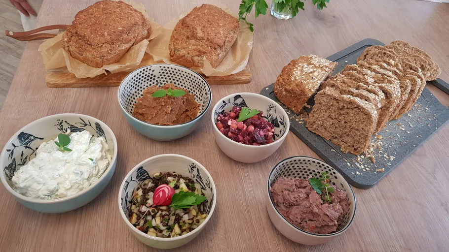 Assorted dips with bread on wooden table.
