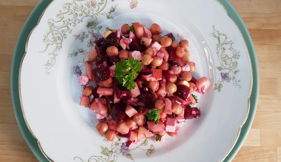 Salat mit Kichererbsen, Rüben und Petersilie auf einem Teller.