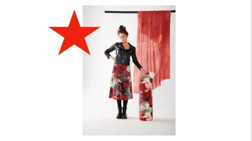 Woman wearing colorful skirt, standing in the studio with clothes.