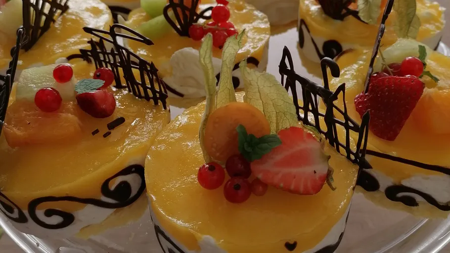 Elegante Mousse-Kuchen mit Fruchtüberzug sind ausgestellt.