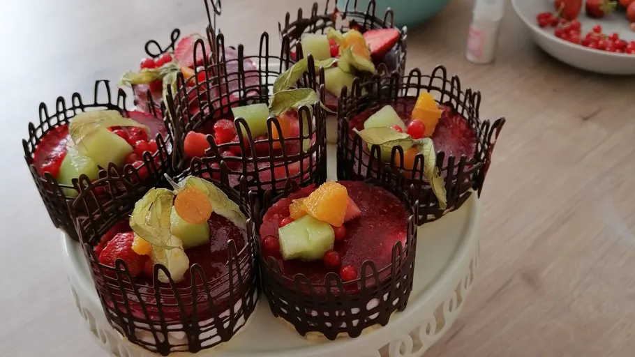 Kuchen mit Fruchtüberzug und Schokoladengitterdekor.