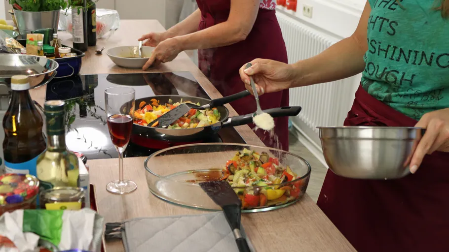 Chefs prepare vegetables in a modern kitchen.