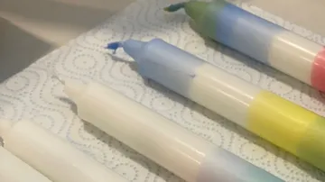 Bunte Kerzen auf Küchenpapier, bereit zum Bemalen.