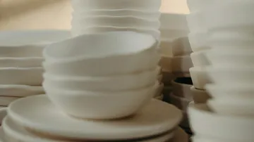 Schalen und Teller stapeln sich in einer hellen Umgebung.
