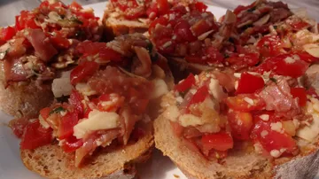 Brot mit Tomaten und Schinken, appetitlich angerichtet.